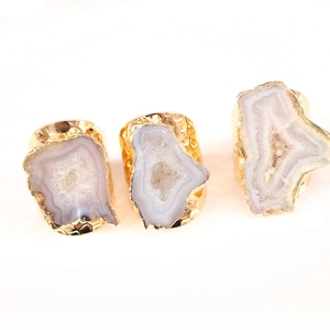 Natural agate geode adjustable rings with gold plated edges on a white background