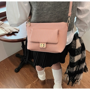 Détail du sac à bandoulière en velours côtelé rose avec fermoir rotatif et sangle réglable