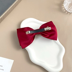 Detail view of the silver metal spring clip on the red velvet ribbon hair bow accessory