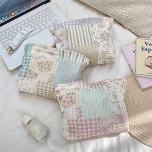 Three quilted floral cosmetic bags set in pastel patchwork colors with fabric labels