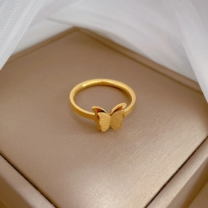 Macro detail of gold butterfly ring showing dual matte and mirror polished finishes