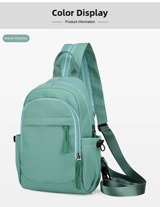 Detail view of the green nylon sling backpack showing zipper pockets and adjustable strap.