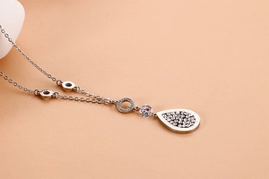 Detail of silver leaf necklace with zirconia drop pendant engraved with Love and Forever