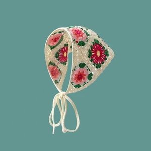 Close-up of handmade crochet floral pattern on a vintage bohemian knit headscarf