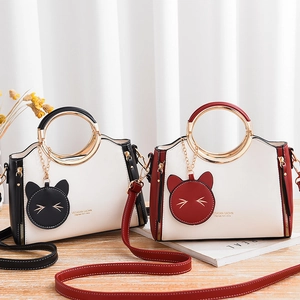 Fashionable PU leather handbags with metal ring handles and cute cat charms in two colors
