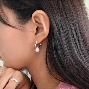 Elegantly designed sterling silver heart and pearl drop earrings shown on model