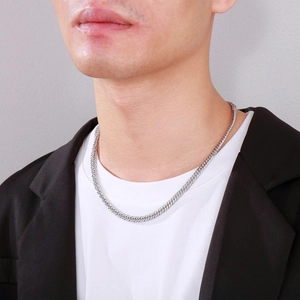 Close-up of a men's silver stainless steel Cuban link chain necklace on model