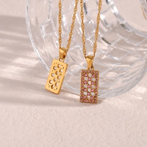 Detail of gold hollow maze pendant necklace with pink zircon on twisted rope chain