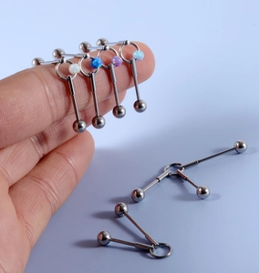 Detailed view of industrial barbell earring with opal stone balls and stainless steel chain