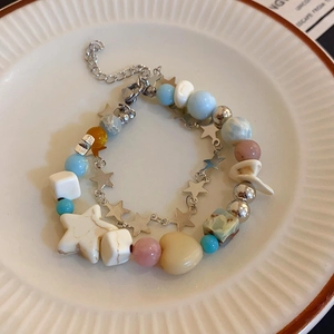 Close-up of double-layer beaded bracelet with macaron stars and hearts in a ceramic plate