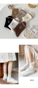 Detailed view of women's cotton socks with ruffles and flower embroidery on the ankle