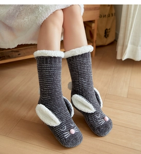 Detail of gray knit winter socks with cute bunny ears and soft white faux fur lining