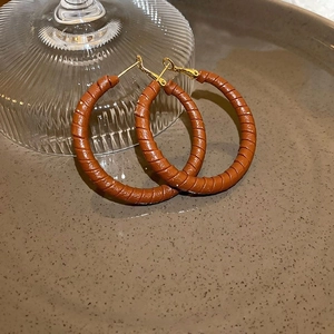 Detail of vintage leopard print hoop earrings with brown textured wrap and gold pins