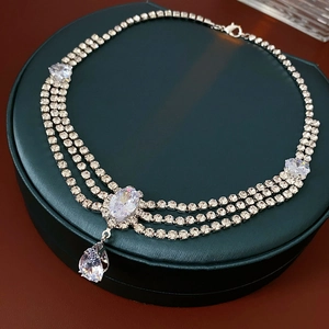 Macro detail of silver layered rhinestone necklace with waterdrop pendant on jewelry box
