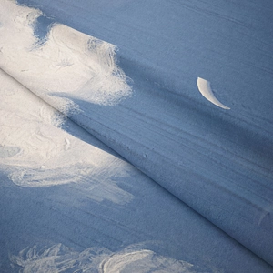 Close-up of bohemian blue tapestry fabric showing soft velvet texture and white cloud print