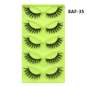 Detailed view of 5 pairs of black fox-eye cat-eye false eyelashes in a light green tray