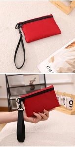 Gros plan sur un porte-monnaie rouge en nylon avec zip noir et dragonne détachable