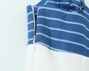 Detail of white invisible zipper on blue striped and white patchwork fabric