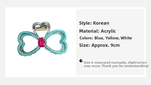 Detail view of a 9cm acrylic bow claw clip featuring blue edging and a pink rhinestone