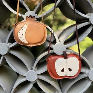 Close-up of fruit-shaped leather crossbody bags with apple and pomegranate designs
