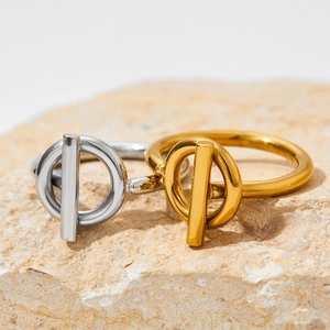 Polished stainless steel OT toggle rings in silver and gold on a natural stone base