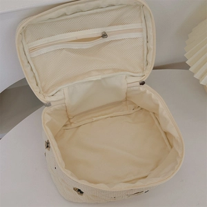 Detail view of corduroy makeup bag with mesh zipper pocket and cute bear embroidery