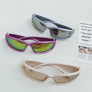 Three pairs of stylish kids sunglasses in purple, silver and beige on a white textured surface