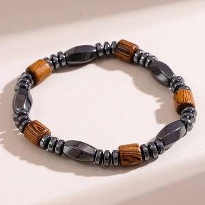 Detail of beaded men's bracelet with hematite stones and cylindrical wooden beads