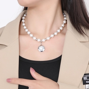 Detail of French pearl necklace featuring a round crystal pendant on a silver clasp