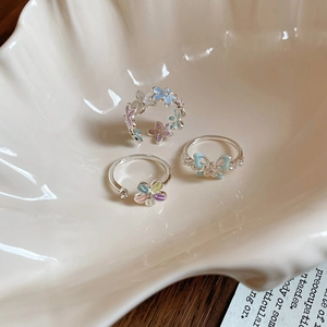 Détail de bagues fleurs et nœuds avec zircons sur un plateau décoratif en céramique