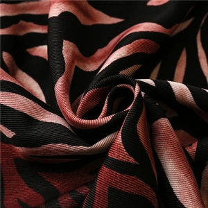 Close-up of zebra pattern silk scarf fabric with pink and brown fringe detail