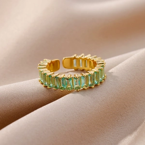 Macro detail of emerald green baguette-cut crystals on adjustable gold-plated ring