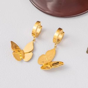Detailed close-up of golden bow hoop earrings featuring fine textured metal finish