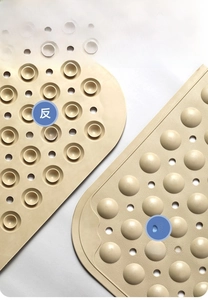 Detail showing non-slip textured surface, drainage holes and suction cups of a bath mat