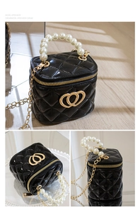 Detail display of black mini silicone bucket bag with pearl handle and golden heart buckle
