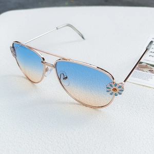Detailed view of rose gold aviator sunglasses with blue daisy decoration and gradient lenses