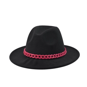 Detail of black wool fedora featuring a vibrant magenta thick chain decoration