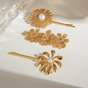 Detail of 18k gold floral hair clips set with pearls and intricate petal textures