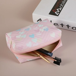 Pink heart patterned PVC makeup bag with V-shaped quilting and zipper closure