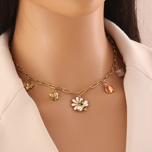 Gold stainless steel necklace with enamel daisy bee and butterfly charms on a model