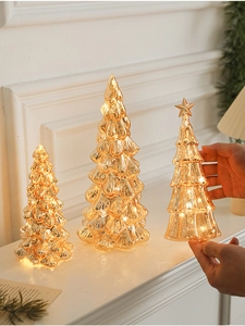 Close-up of golden mercury glass Christmas trees with warm LED light in three sizes