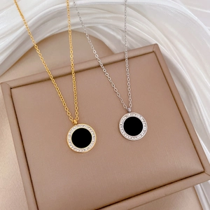Detailed view of gold and silver titanium necklaces with round agate and zircon pendants