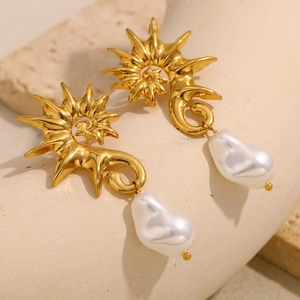 Vue macro de boucles d'oreilles hippocampe dorées 18K avec perles baroques sur pierre
