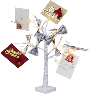 Close-up of LED birch tree branches with warm lights and clips for cards and money