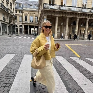 Chic yellow quilted plaid jacket paired with white pleated skirt and woven handbag