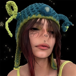 Detailed view of handmade crochet devil horn beanie in blue and neon green knit fabric