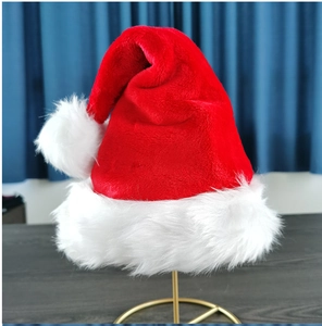 Détail du bonnet de Noël en peluche rouge avec bordure blanche et gros pompon moelleux