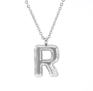Macro shot of silver puffy bubble letter R pendant on a polished stainless steel chain