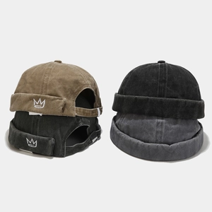 Détail de la broderie couronne et boucle métallique sur les bonnets docker délavés