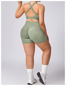 Detail of cross-back sage green sports bra and high-waist yoga shorts set for women